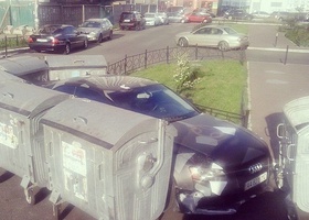 Мешавшую въезду во двор машину заставили мусорными контейнерами (фото)